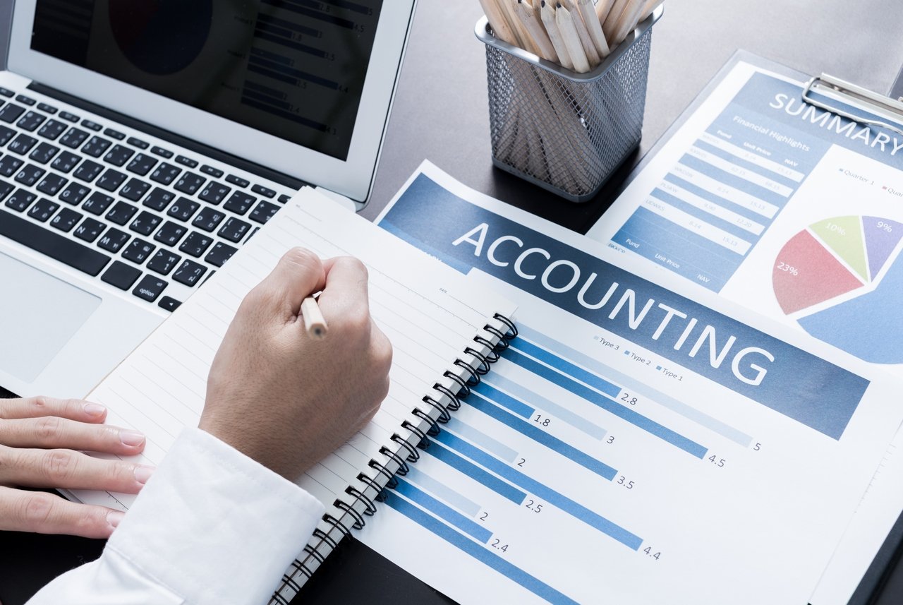 Accountant reviewing financial charts and reports with a laptop, representing digital marketing for accounting practices